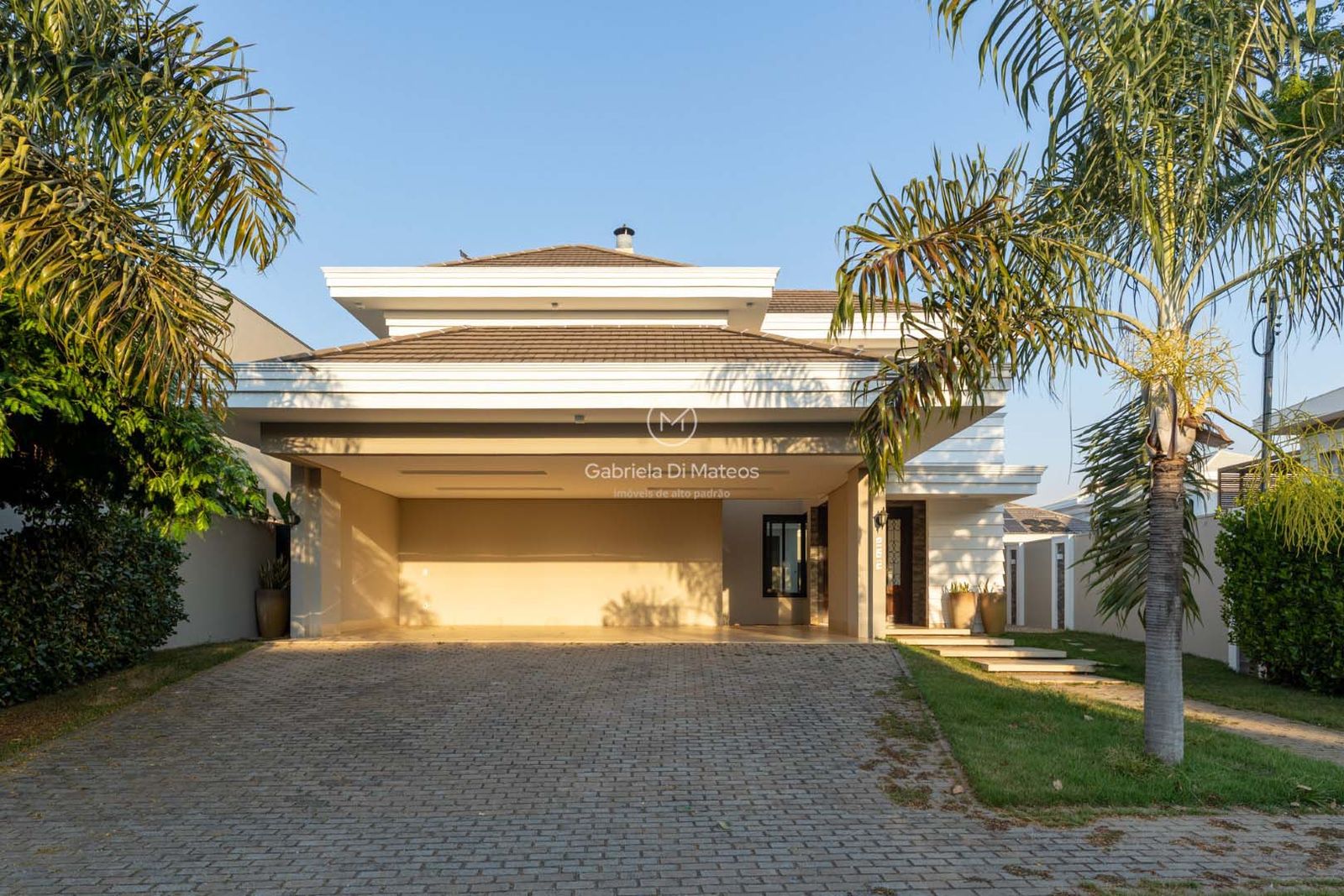 Entrada da casa com garagem coberta e acesso pavimentado no condomínio Carpe Diem