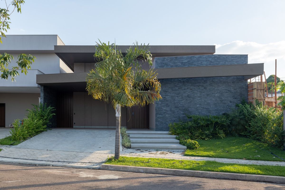 Casa contemporânea com paisagismo e palmeira no condomínio Alameda das Cores, em Sinop